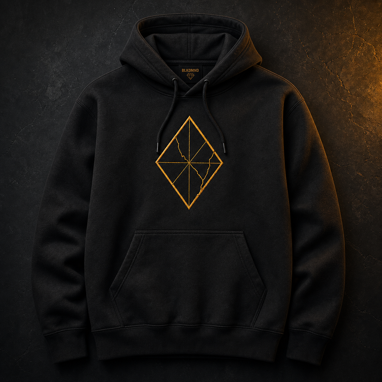 Black hoodie mockup with an amber cracked diamond mark